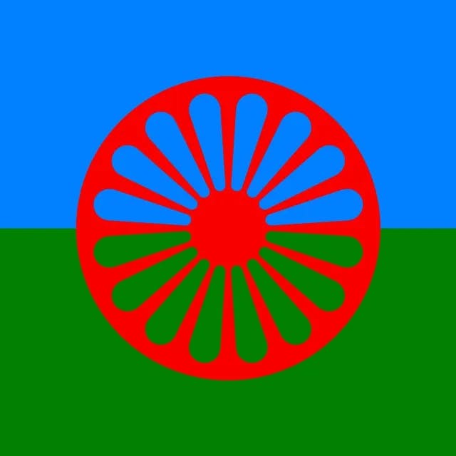 Flagge der Rom*nja und Sinti*zze. Flagge der Rom*nja und Sinti*zze. Sie ist Blau in der oberen Hälfte und Grün in der unteren Hälfte. Außerdem enthält die Flagge mittig ein Speichenrad. im Zentrum der Flagge.